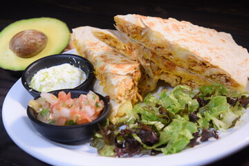 Mexican beef tortilla, guacamole, avocado salad, salad, delicious snack isolated on black background, viewed from above.