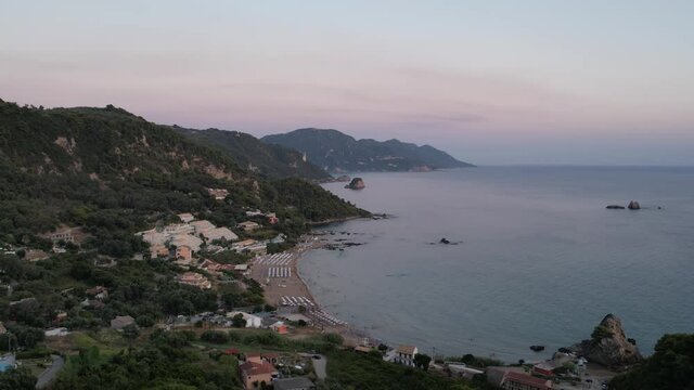 Aerial drone view over western coast and Pelekas beach at sunset. Island of Corfu, Greece.