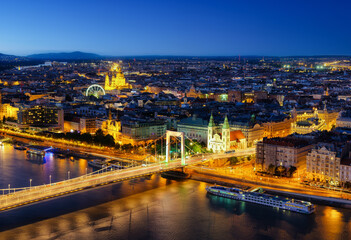 Obraz premium View of Budapest at night, Hungary. A cityscape in Europe. Ferris wheel and ancient architecture. Bridges and the Danube River. Landscape from above.