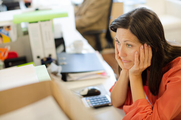 Businesswoman thinking at desk