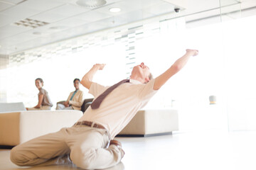 Businessman cheering on floor in office