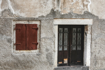 wall with window shutters and a door
