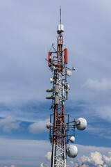 Steel broadcasting antenna tower with forest, sky and clouds in background. Eastern Slovakia near High Tatras.