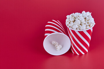 Two glasses with popcorn on a red background