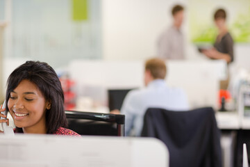 Businesswoman talking on phone at desk