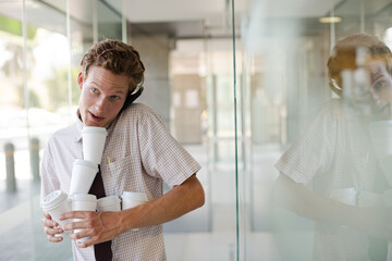 Businesswoman balancing coffee cups in office