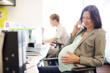 Businesswoman talking on phone at desk
