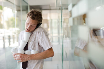 Businesswoman balancing coffee cups in office