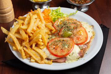 milanesa napolitana con papas fritas en mesa de restaurant