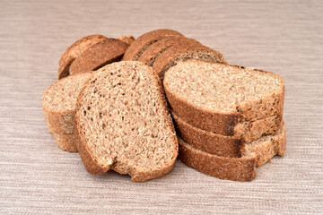 Stack of sliced fresh homemade wholegrain unleavened brown bread on the rustic wooden table