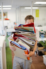 Businessman balancing folders in office