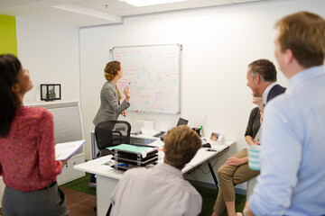 Obraz premium Businesswoman drawing on whiteboard in meeting