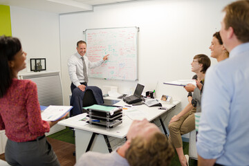 Obraz premium Businessman drawing on whiteboard in meeting