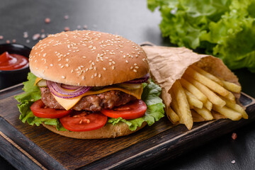 Craft beef burger and french fries on a black background