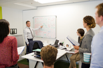 Obraz premium Businessman drawing on whiteboard in meeting