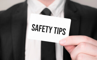 Businessman holding a card with text Safety tips