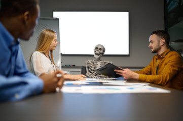 Team of managers and skeleton in IT office, joke