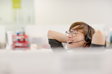 Businesswoman talking on headset at desk