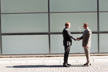 Businessmen shaking hands outdoors