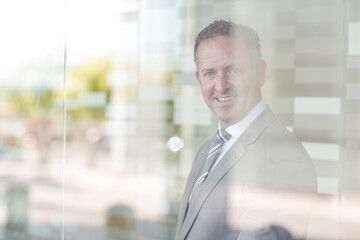 Businessman smiling at office window