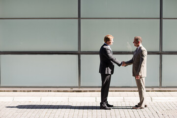 Businessmen shaking hands outdoors