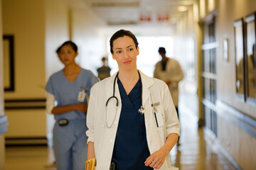 Doctor carrying folders in hospital