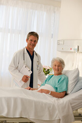 Fototapeta premium Portrait of smiling doctor and senior patient in hospital room