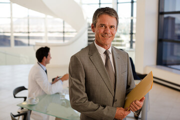 Portrait of smiling businessman in meeting with doctors