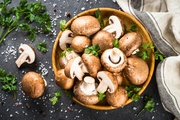 Champignon. Fresh organnic mushrooms in wooden bowl ready for cooking. Top view.