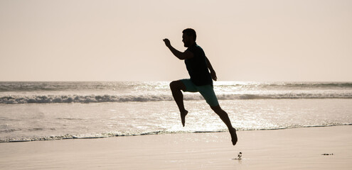 Fototapeta na wymiar silhouette of athletic man runner running on summer beach, jogging