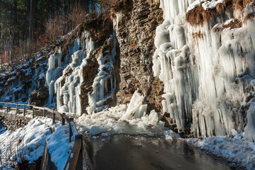 Naklejka na ściany i meble A lot of ice on a road, blocked due to an icefall