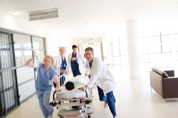 Doctors rushing patient on gurney in hospital corridor