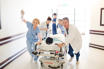 Obraz premium Doctors rushing patient on gurney in hospital corridor