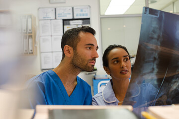 Fototapeta premium Surgeons examining x-rays in hospital