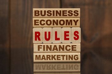 Wooden blocks with the text - Business, Economy, Finance, Marketing and RULES