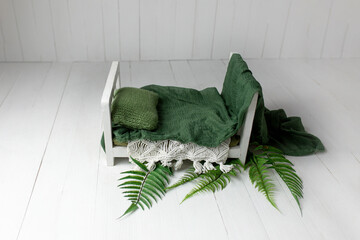 the wooden bed is decorated with a fern. props for a photo shoot of newborns. background for a photo shoot. furniture for dolls