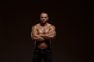 Fototapeta na wymiar Male muscular athlete shows his power in studio