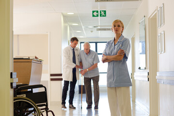 Doctor and nurse standing with patient in hospital hallway