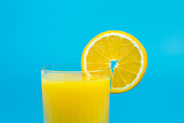 Healthy orange juice with fresh fruit on blue background