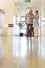 Older patient and nurse standing in hospital