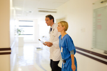 Fototapeta premium Nurse and doctor walking in hospital hallway
