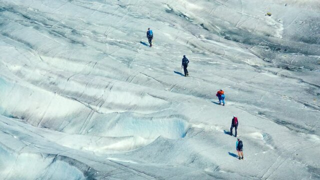 A group of climbers in a bundle walking along the glacier