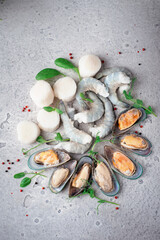 Mixed frozen seafood on a gray stone background. Raw Shrimp, mussels and scallops