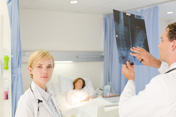 Doctors examining x-rays in hospital room