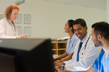 Obraz premium Hospital staff talking at front desk
