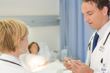 Doctor checking syringe in hospital room