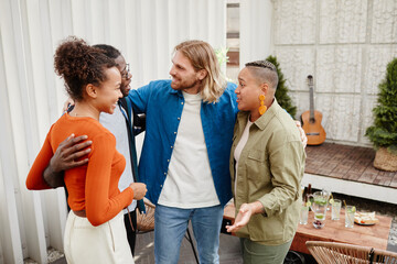 Diverse group of modern young people greeting each other at rooftop party, copy space
