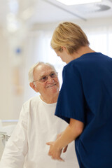 Obraz premium Nurse reading older patient's medical bracelet in hospital
