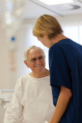 Fototapeta premium Nurse reading older patient's medical bracelet in hospital