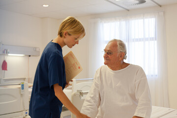 Obraz premium Nurse talking with older patient in hospital